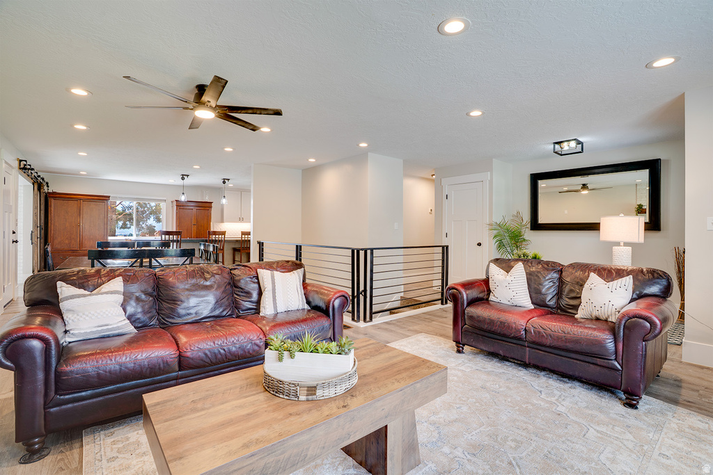 Open-concept living space featuring recessed lighting, a ceiling fan, and wood-finish flooring