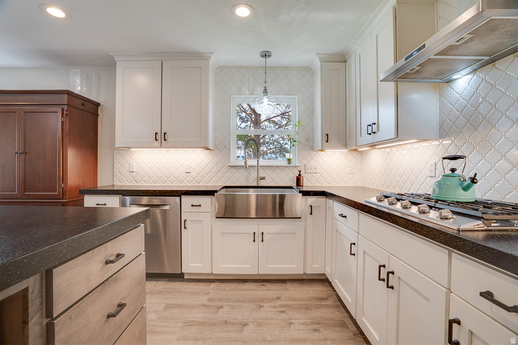 Chef's kitchen featuring crisp white cabinetry with brushed nickel hardware, quartz countertops, a farmhouse-style apron-front sink with polished stainless steel fixtures, and professional-grade gas cooktop