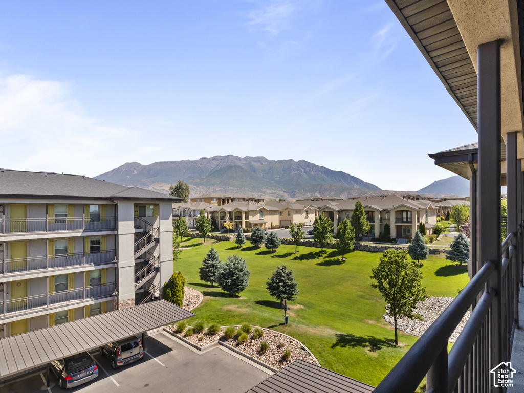 Expansive mountain scenery framing a landscaped green space with mature trees