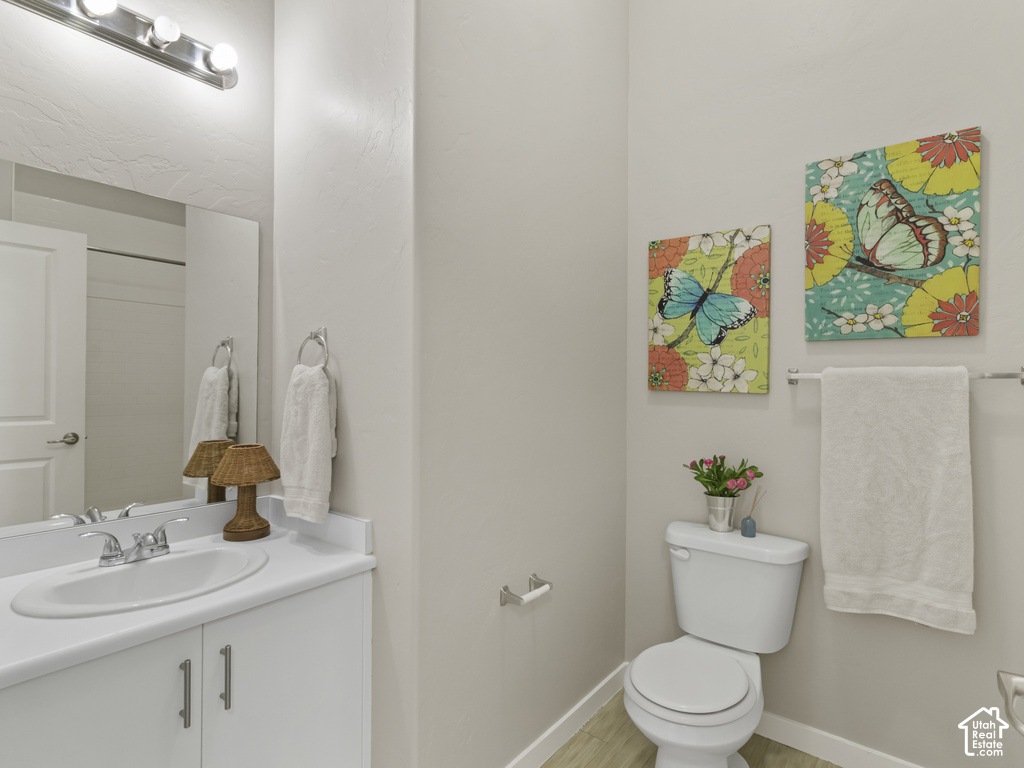 Bathroom featuring a white vanity with integrated sink, chrome faucet, and a large wall-mounted mirror