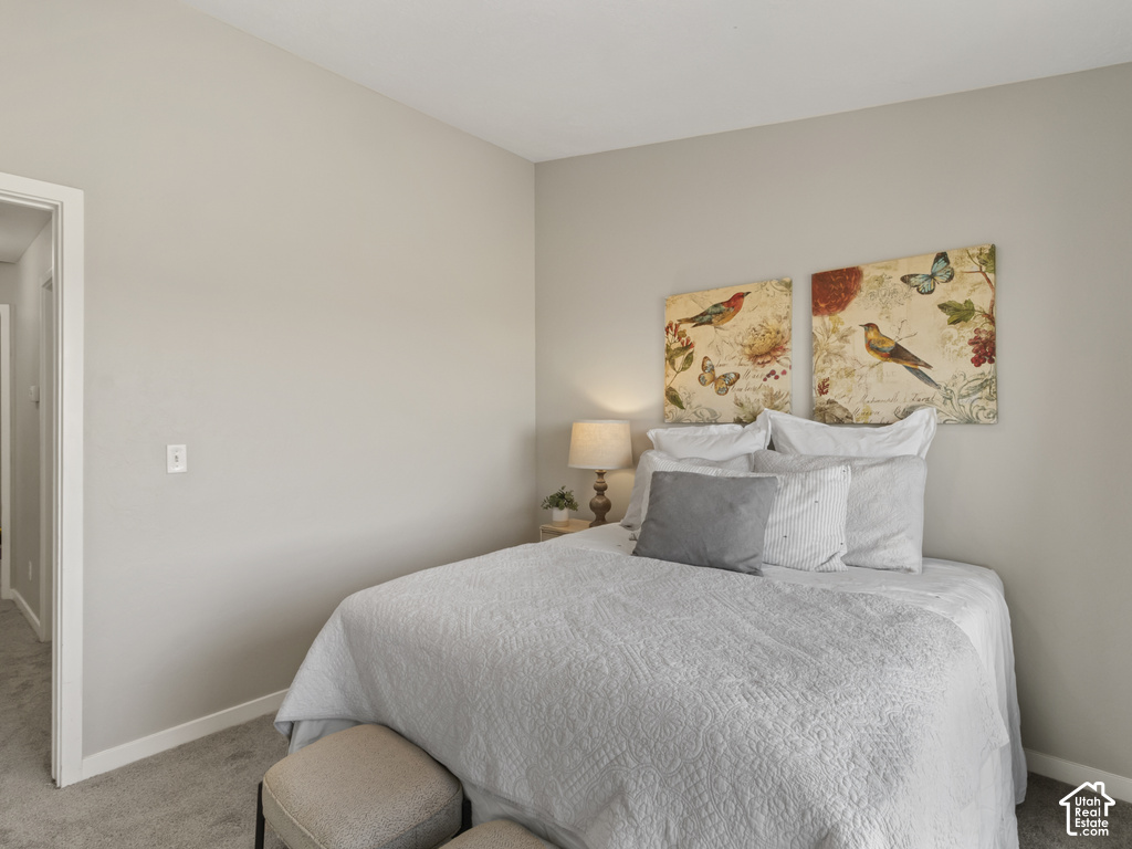 Neutral-toned bedroom featuring wall-to-wall carpeting and crisp white trim