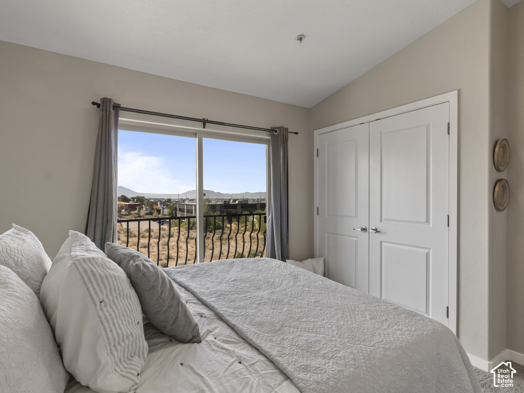 Spacious room featuring a vaulted ceiling and sliding glass doors opening to a private balcony