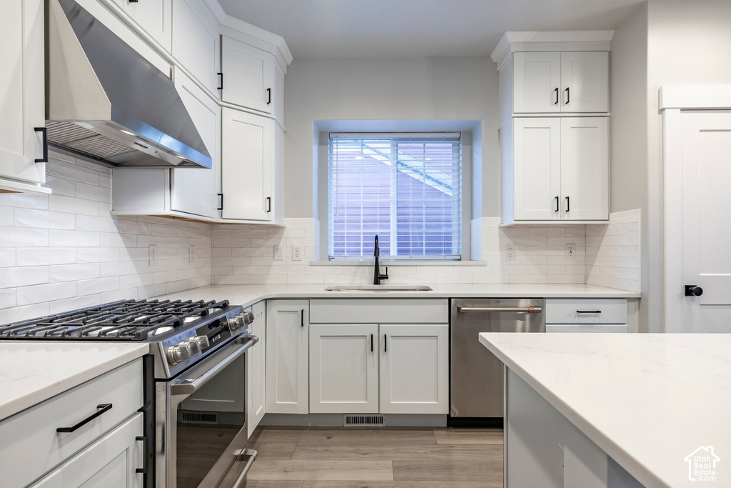 Modern kitchen featuring white shaker-style cabinetry with brushed black hardware, white subway tile backsplash, and quartz countertops