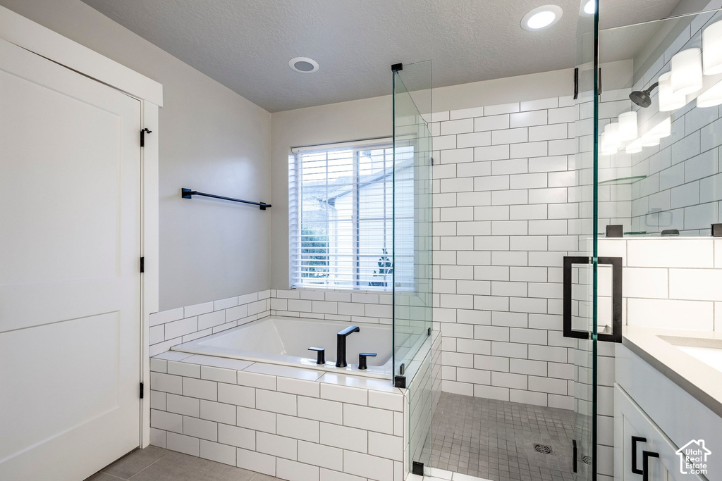 Contemporary bathroom featuring a built-in tub with matte black fixtures, a walk-in shower with clear glass enclosure and subway tile surround, and a vanity with a light gray countertop