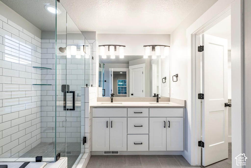 Dual vanity with quartz countertop, white cabinetry, and matte black fixtures