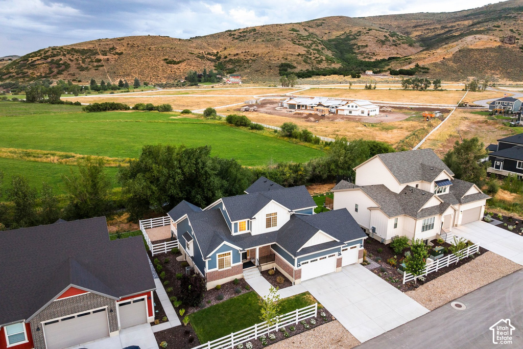 Modern residential property with a two-car garage, concrete driveway, and white picket fencing