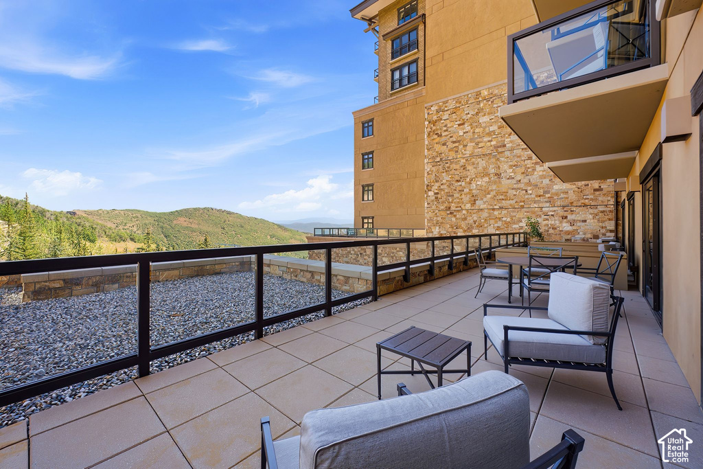 Spacious outdoor terrace with large format patio pavers and glass panel railing