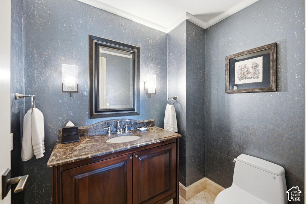 Powder room featuring a dark wood vanity with a stone countertop and an undermount sink