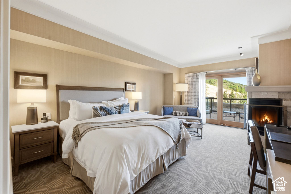 Spacious room featuring a stone fireplace, wood-finish French doors opening to an exterior balcony, and light-toned patterned carpeting