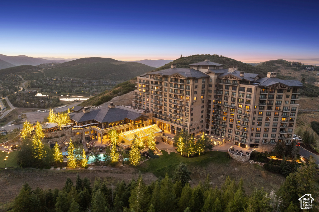 Multi-story building featuring numerous balconies and a large, multi-level recreational area with multiple pools