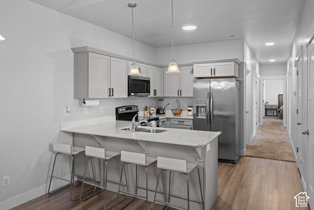 Modern kitchen featuring stainless steel appliances, white cabinetry with hardware accents, and white quartz countertops