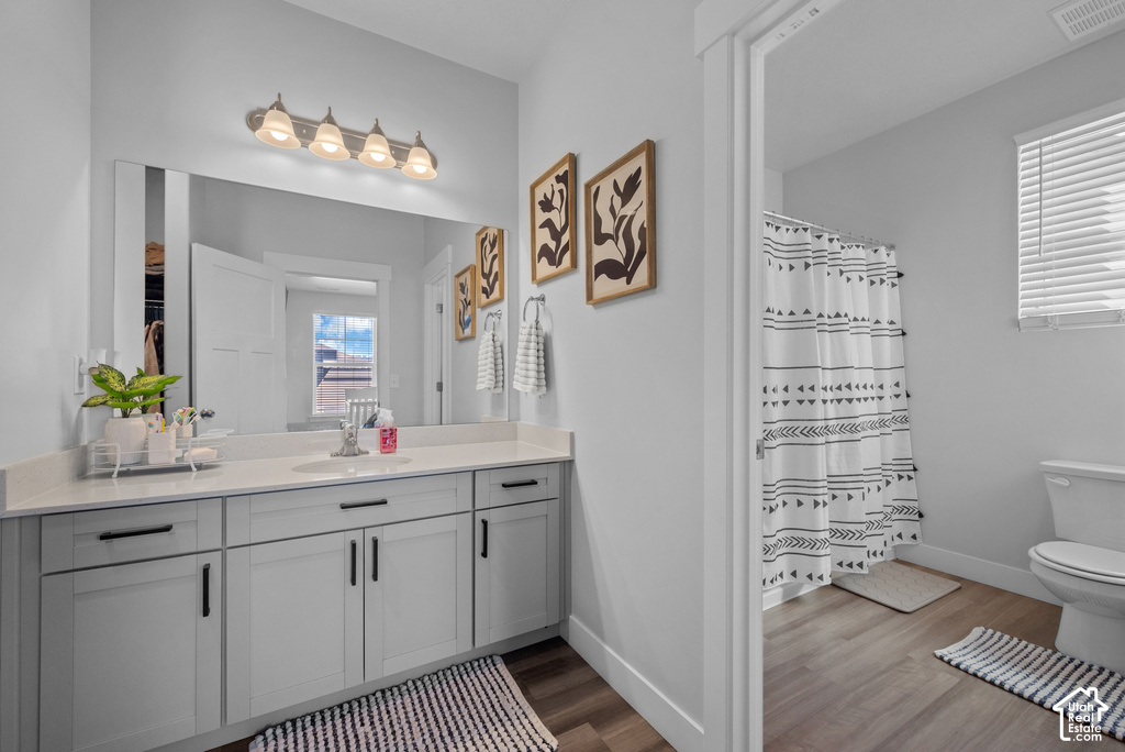 Spa-inspired primary bathroom featuring a gray dual-vanity with ample storage, quartz countertop, and chrome hardware