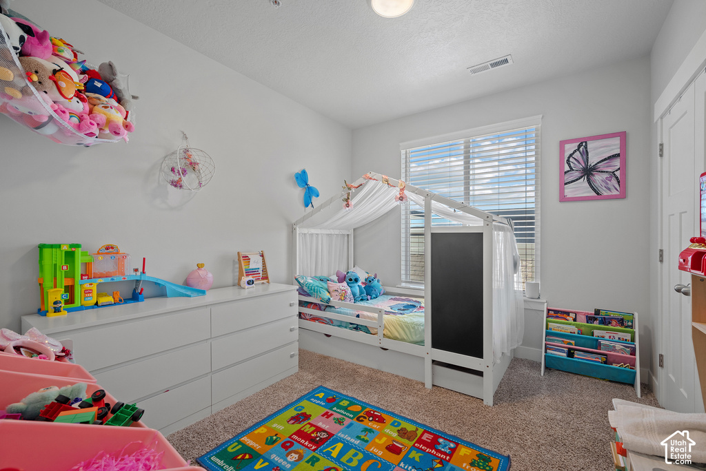 Bright, well-appointed children's bedroom featuring abundant natural light from dual shuttered windows, carpeted flooring, and generous storage throughout