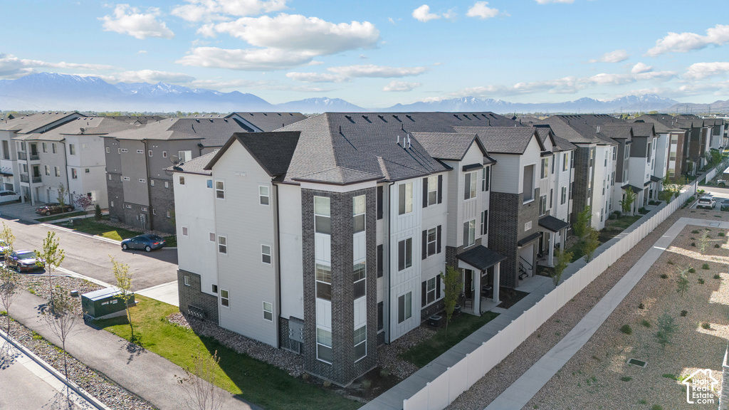 Modern multi-unit residential complex featuring clean architectural lines, mixed exterior finishes in white and dark gray tones, pitched rooflines with dimensional depth, and well-proportioned fenestration across multiple stories