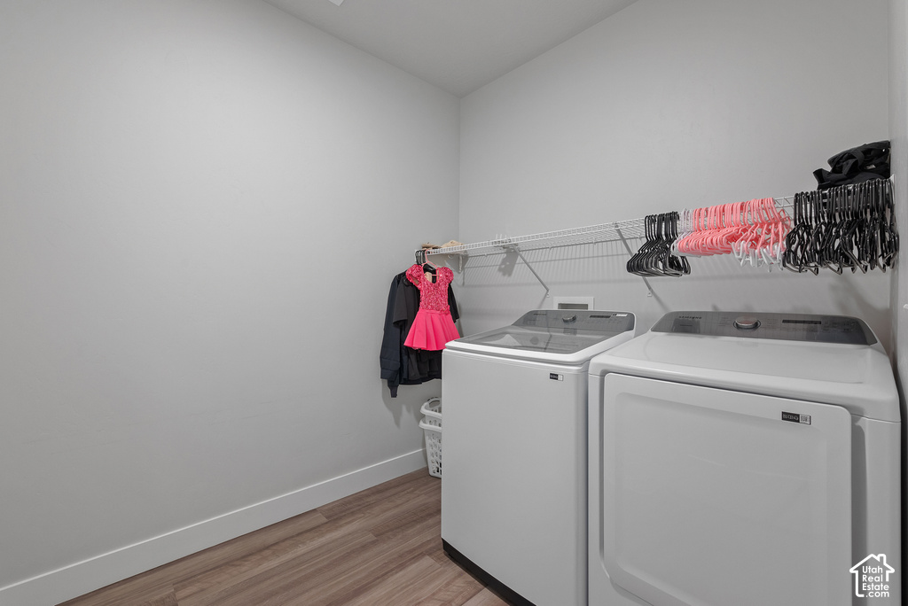 Dedicated laundry area featuring wood-finish flooring and light gray walls