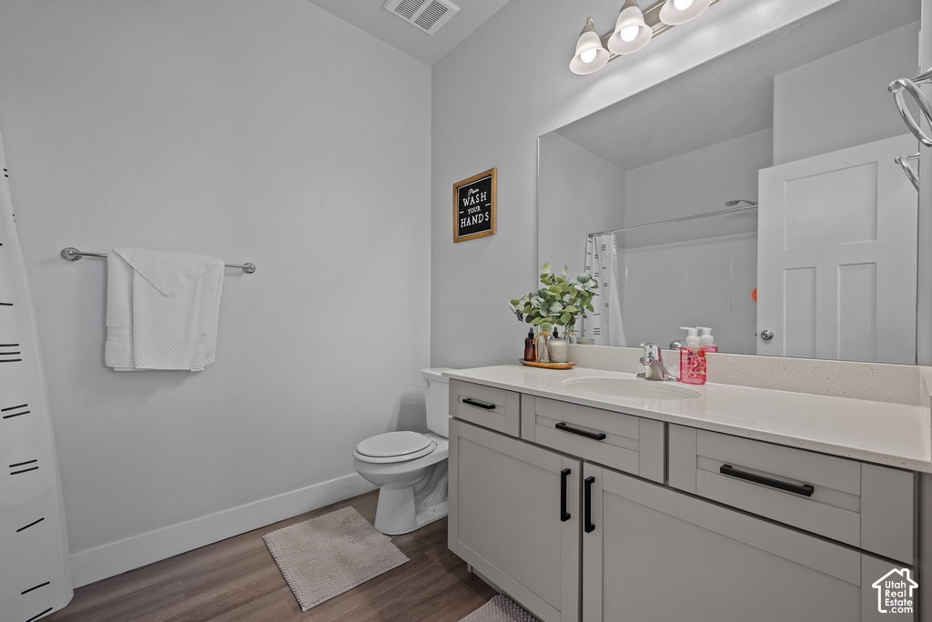 Spa-inspired bathroom featuring a large framed mirror, dual-sink vanity with soft-close cabinetry and black hardware, quartz countertop, and ample storage