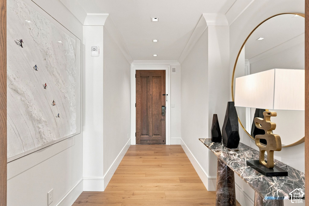 Elegant hallway showcasing wide-plank wood-finish flooring, crisp white walls, and recessed ceiling lighting