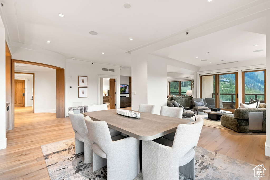 Dining area featuring wood-finish flooring, recessed lighting, and an expansive sliding glass door system