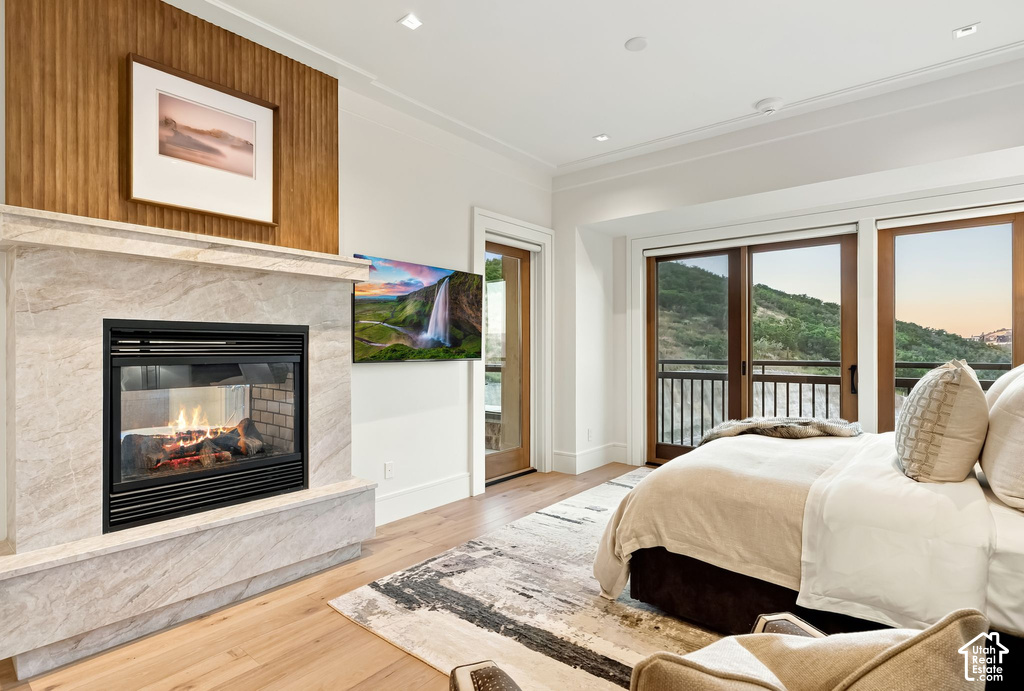 Light wood-finish flooring complements a fireplace featuring a stone surround and hearth