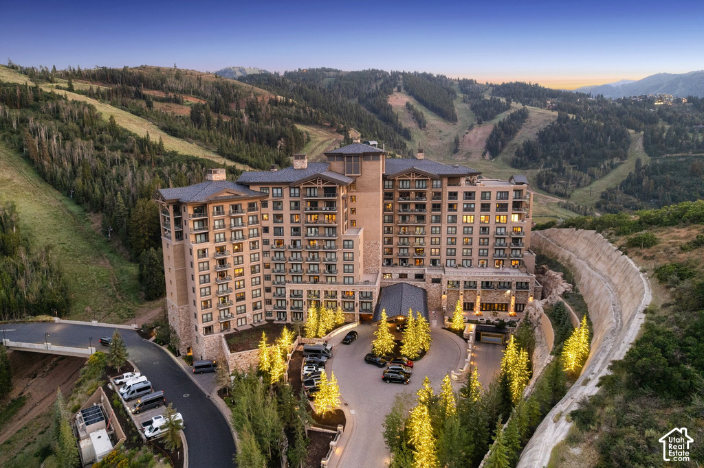 Luxury mountain resort-style residence showcasing a substantial multi-story stone and timber facade with warm-toned exterior finishes