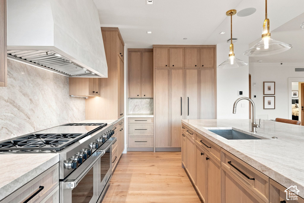 Chef's kitchen featuring custom light wood cabinetry, white marble subway tile backsplash, and marble countertops throughout