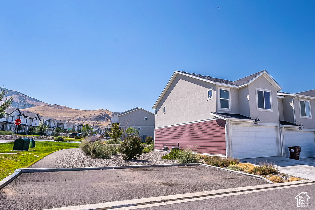 Two-story townhome featuring a neutral stucco exterior and red horizontal siding
