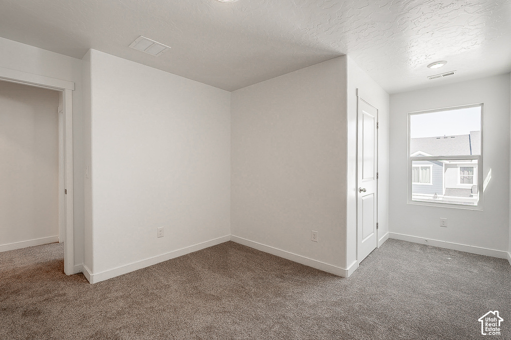 Bright, open bedroom featuring neutral wall finishes, recessed ceiling lighting, and plush carpeting