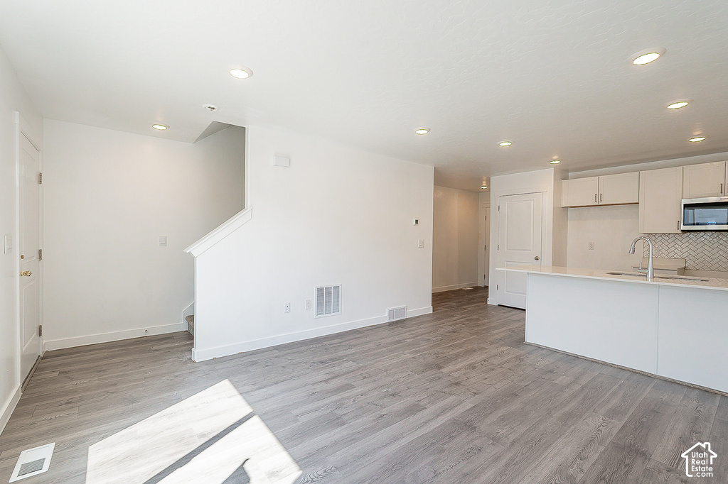 Spacious open-concept interior featuring light wood-finish flooring and recessed lighting