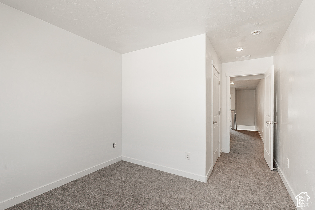 Spacious bedroom featuring neutral walls, plush carpet flooring, and recessed ceiling lighting