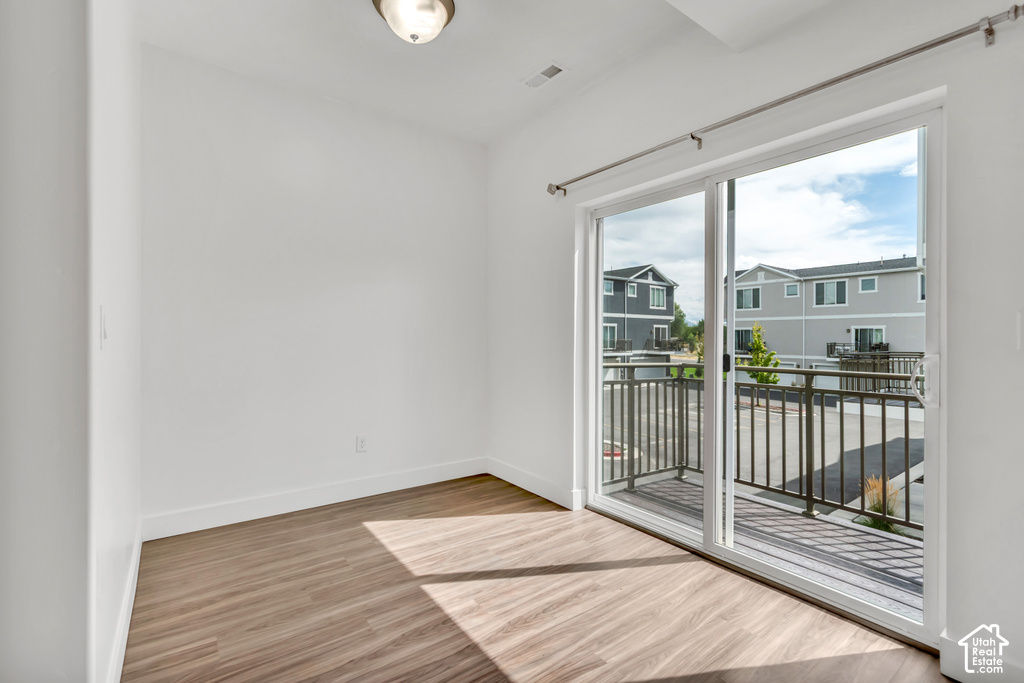Room featuring wood-finish flooring, white baseboards, and a semi-flush mount ceiling light