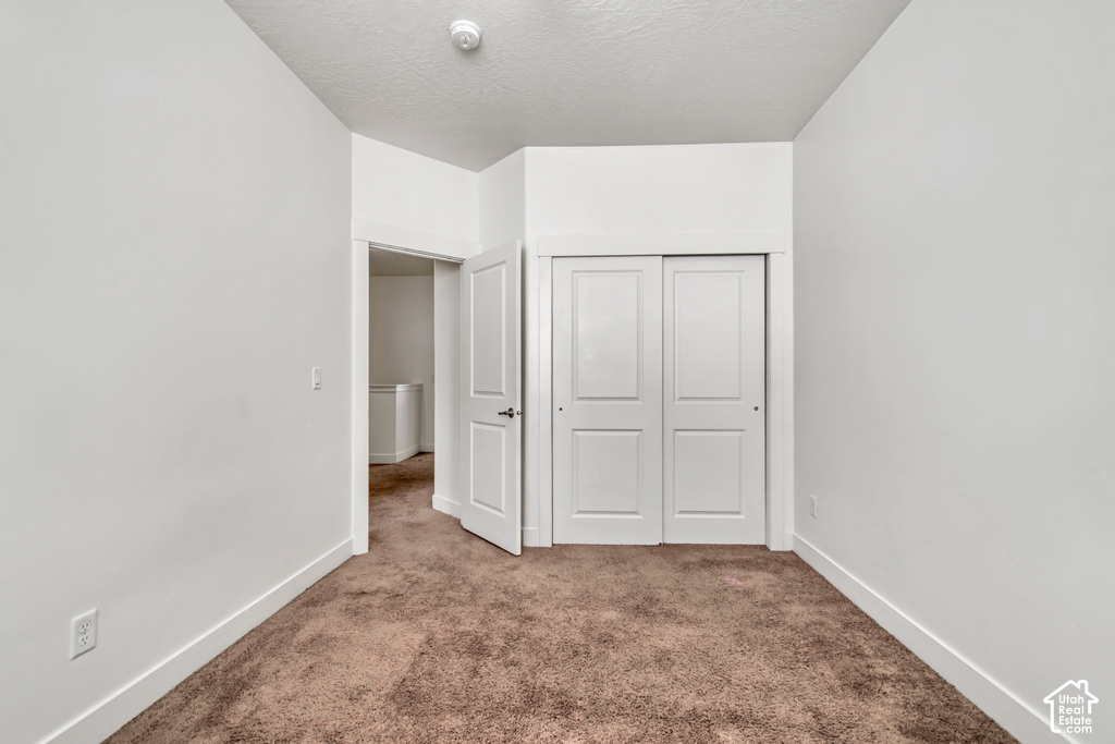 Room featuring brown carpet flooring, white walls, and white baseboards