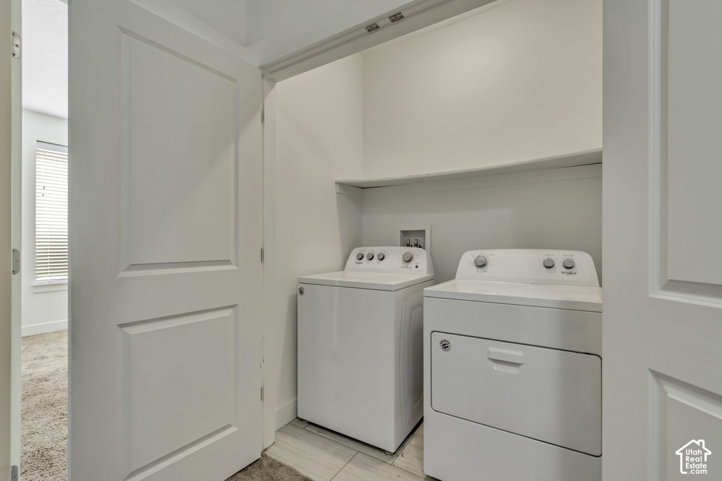 Dedicated laundry closet featuring a built-in shelf, neutral wall tones, and light-toned tile flooring