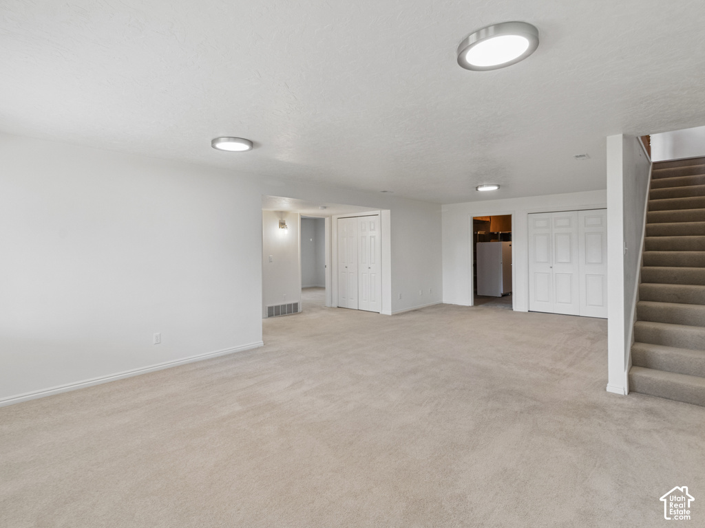 Neutral-toned carpet flooring throughout, complemented by white walls and trim