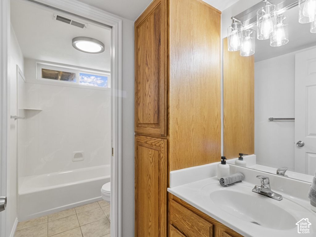 Vanity with integrated sink and chrome faucet, full-width mirror, and wood-finish cabinetry