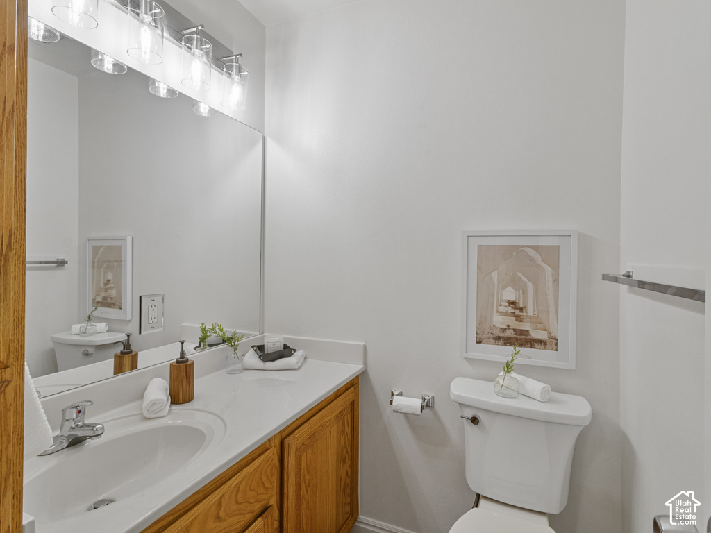 Vanity with integrated sink, wood-finish cabinetry, and a full-width mirror