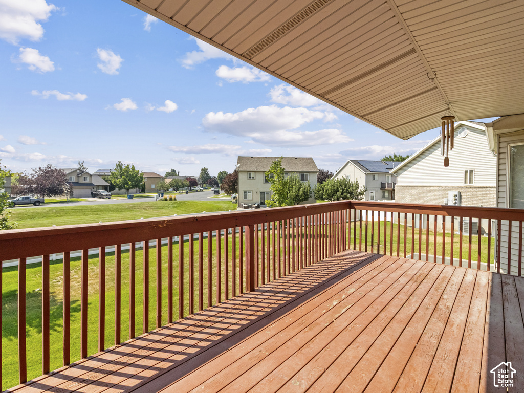 Expansive wood deck with a full-length railing, featuring an attached awning