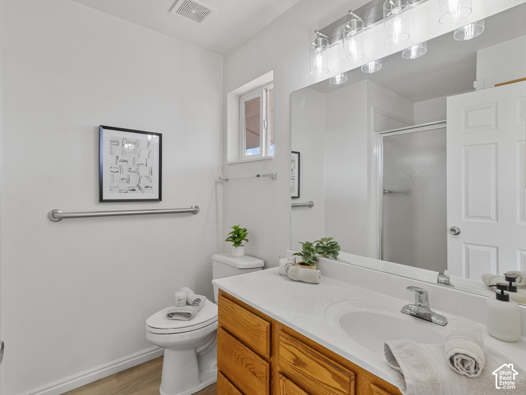 Bathroom featuring a single vanity with wood-finish cabinetry, a white countertop, and a chrome faucet