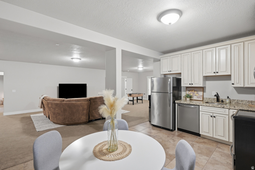 Kitchenette featuring white cabinetry, stone-finish countertops, and stainless steel appliances