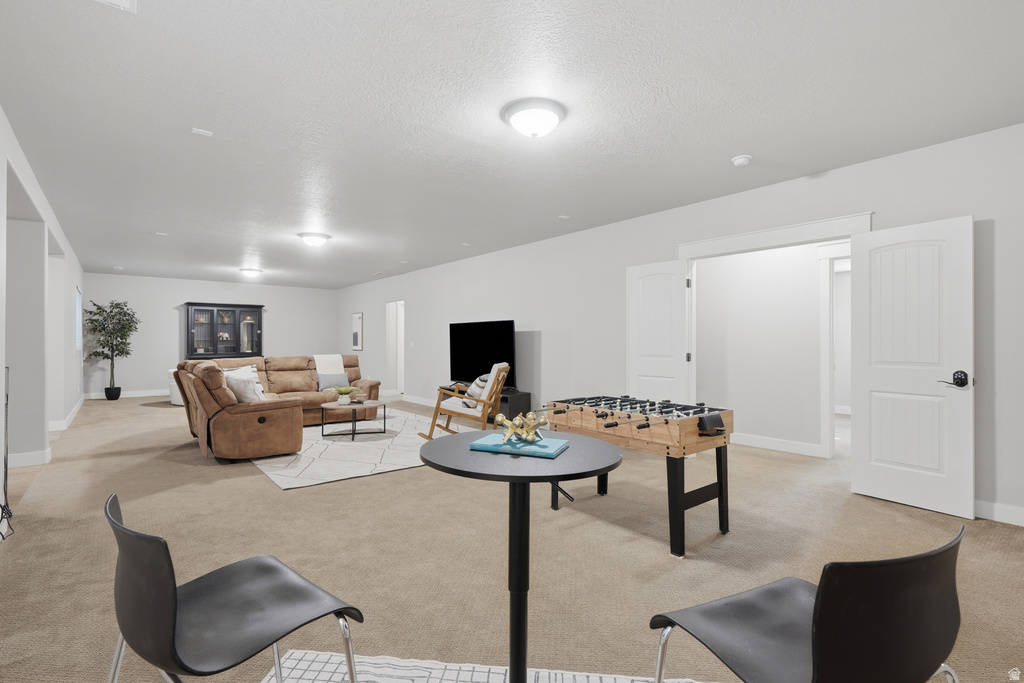 Spacious recreation room featuring neutral carpeting, recessed and flush-mount lighting, and white trim throughout