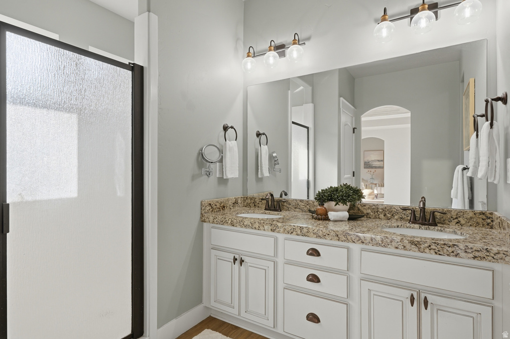 Dual vanity featuring white cabinetry with cup pulls and a speckled countertop