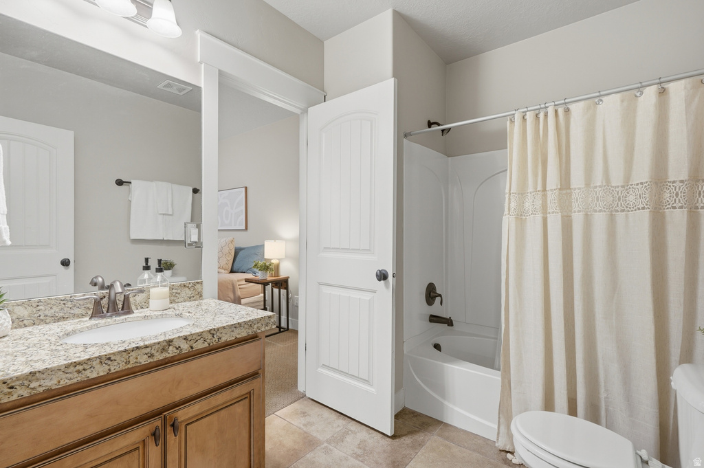 Bathroom featuring a wood-finish vanity with a speckled countertop, an undermount sink, and a modern faucet