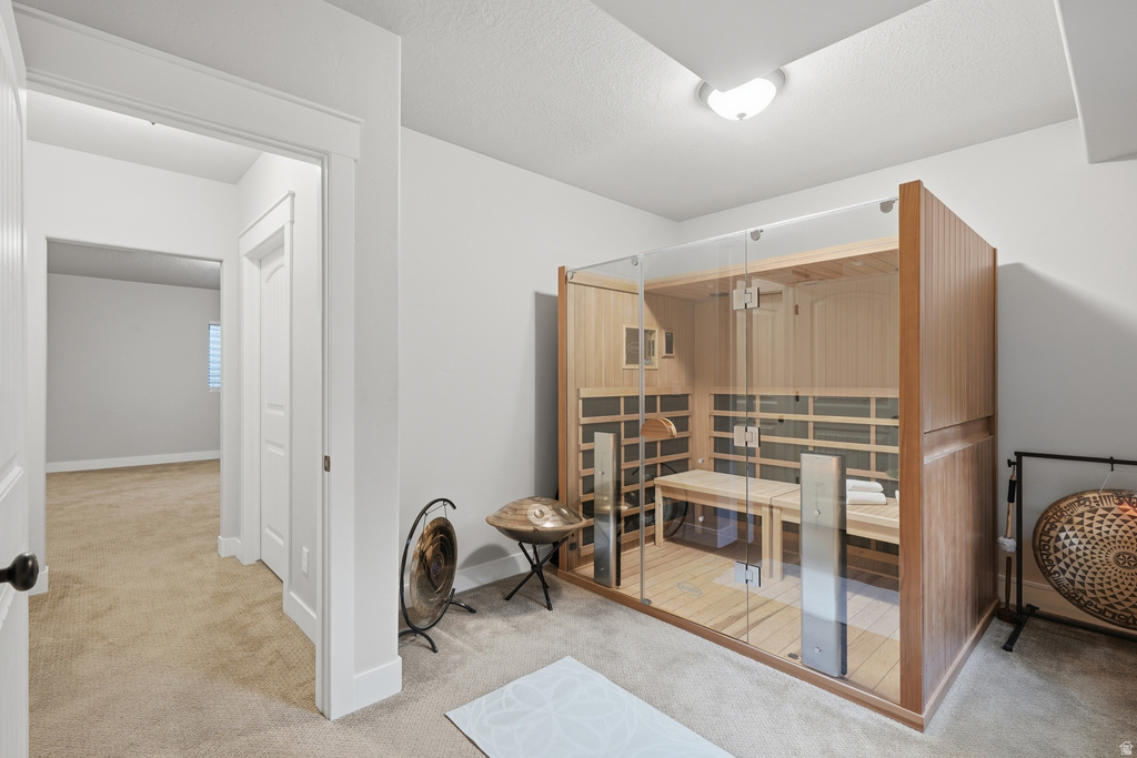 Dedicated room featuring a built-in sauna with clear glass doors and light wood-finish interior