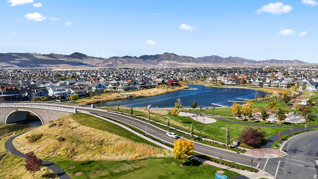 Expansive community featuring a large water body, mature landscaping, and an arched stone bridge