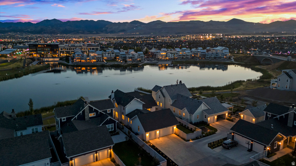 Residential properties featuring varied architectural styles, attached garages, and paved driveways, situated around a central lake