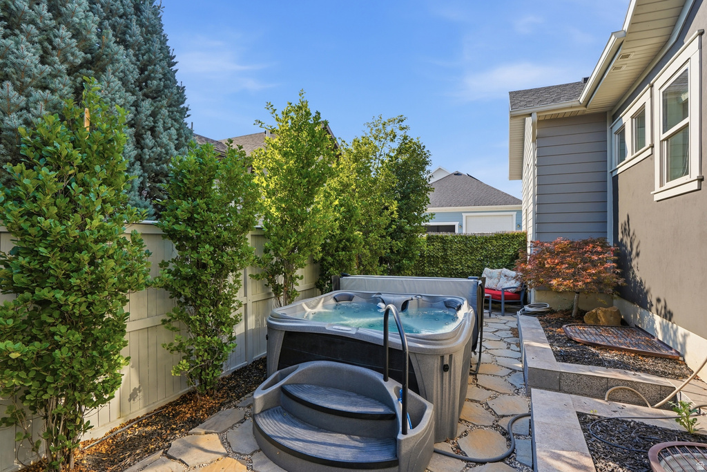 Outdoor spa with steps, surrounded by flagstone paving and mature privacy plantings