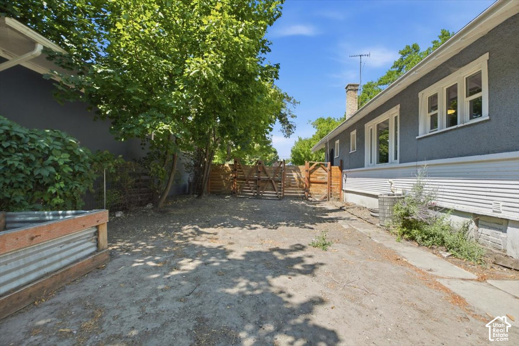 Spacious backyard with mature shade trees, wooden fencing, and direct access to the residence