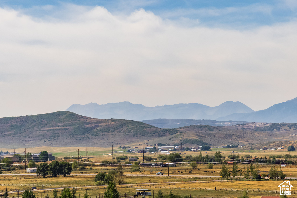 Expansive rural landscape with distant mountains, rolling hills, and open fields