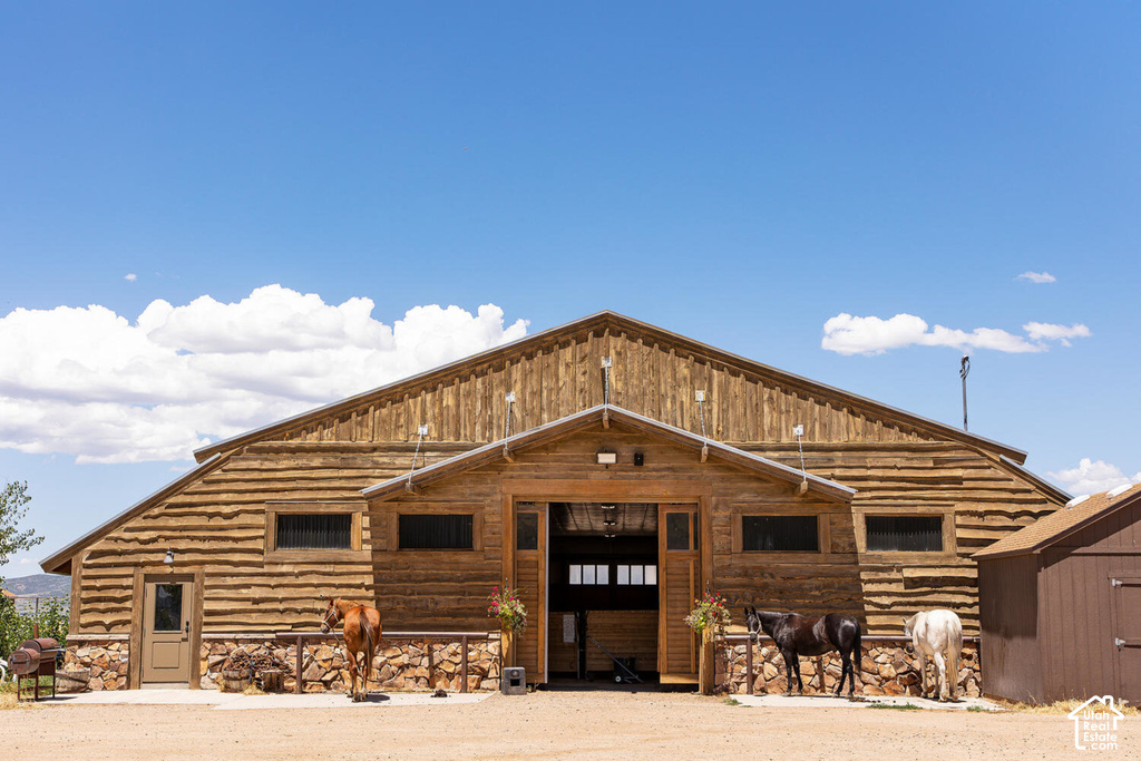 Rustic barn with wood siding, stone foundation, and multiple entry points