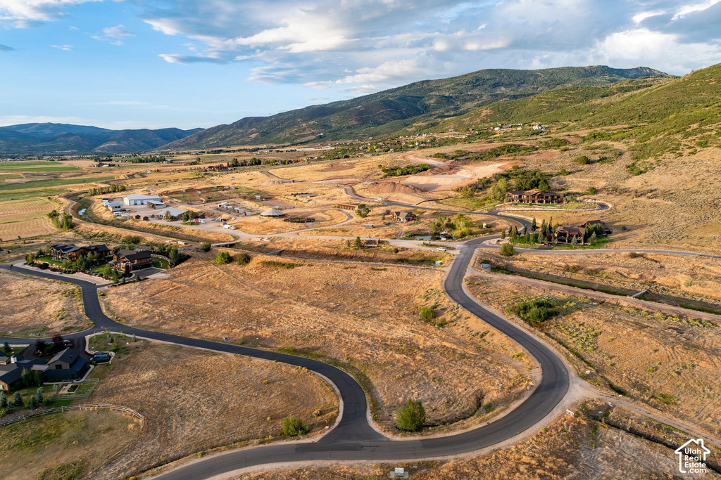 Scenic mountain backdrop, winding paved roads, established residences, natural landscape, undeveloped land parcels