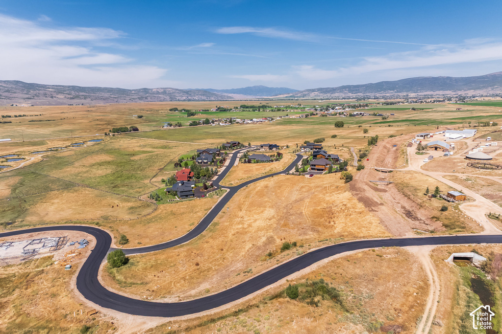 Paved roads winding through developed land, surrounded by expansive natural terrain, with distant mountains under a blue sky
